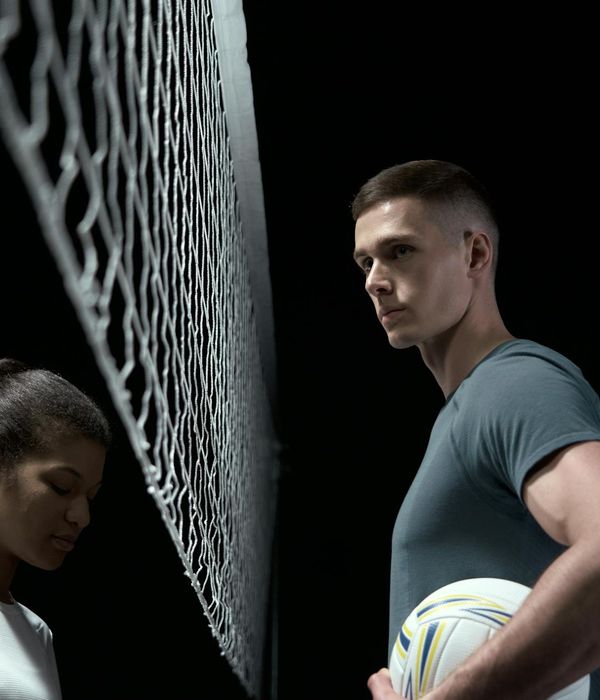 Man in a focused strength pose against a dark background with sea beam color accents.